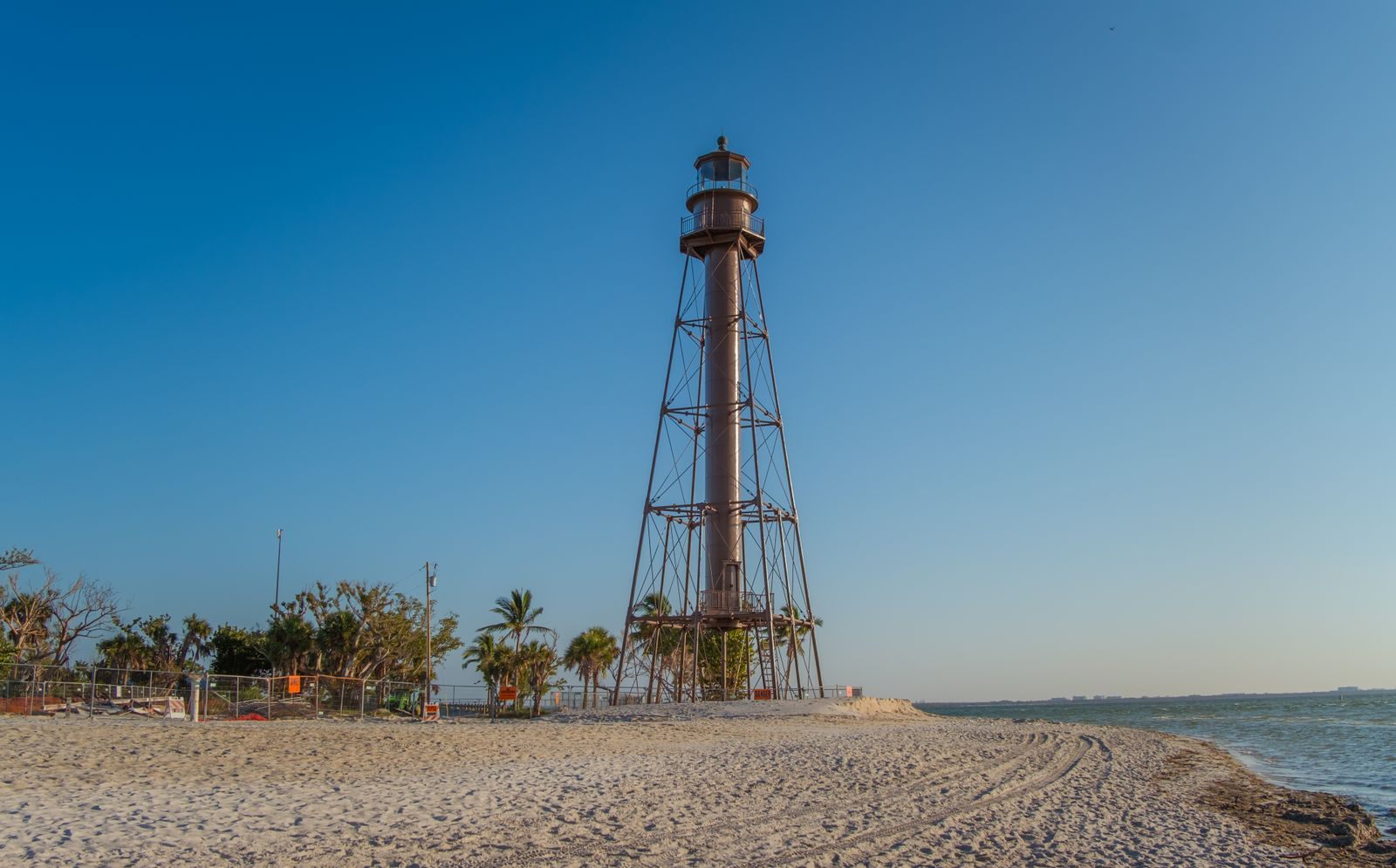 The iron-frame Sanibel Lighthouse above Lighthouse Beach under a clear blue sky